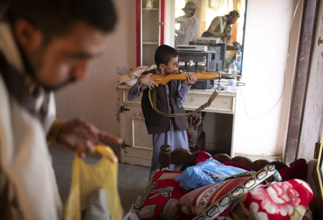A boy tries his uncle's rifle as men gather to prepare their friend for his wedding in Marib. Carrying weapons are a tradition mostly in the northern parts of the country in Yemen with each city having a weapons' market. April 8, 2021